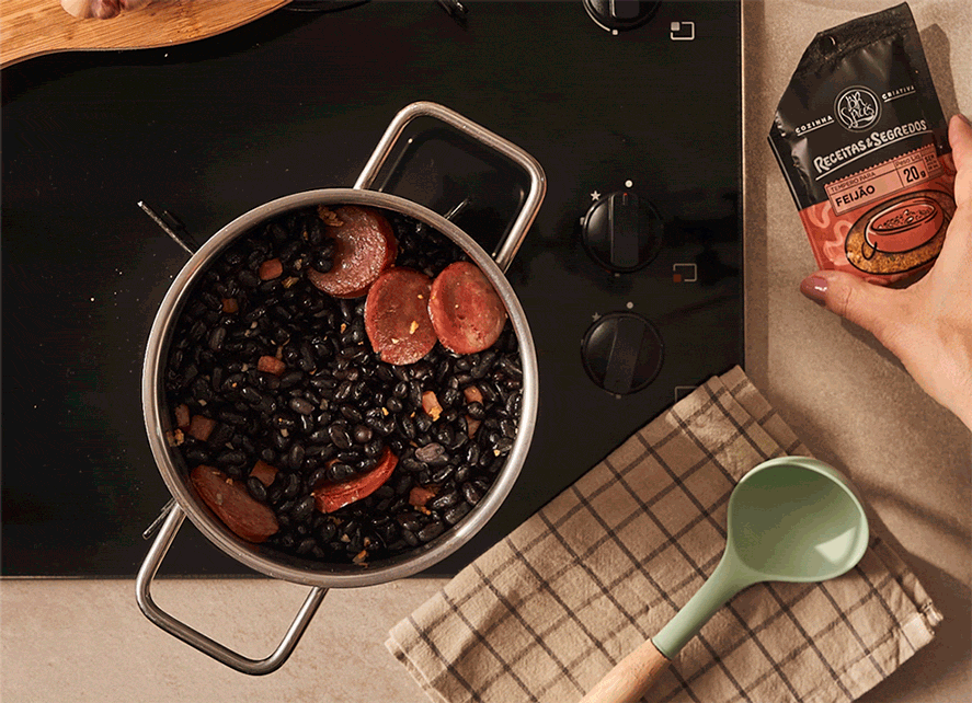 Feijão em panela sendo temperado com Tempero para Feijão da linha Receitas & Segredos