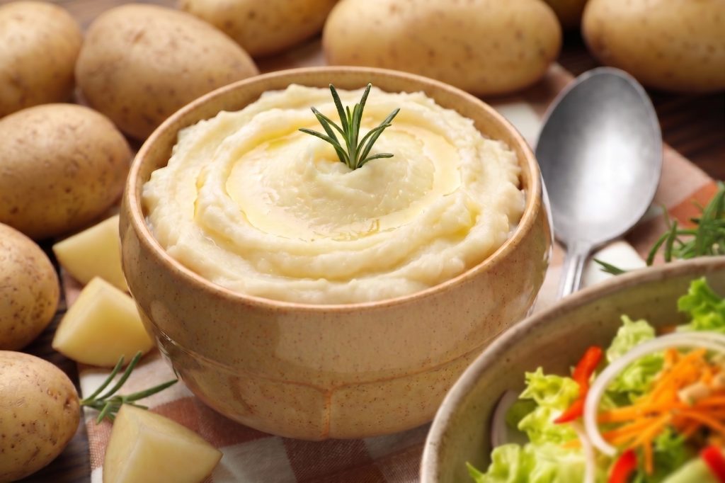 Purê de batata e salada empratados.