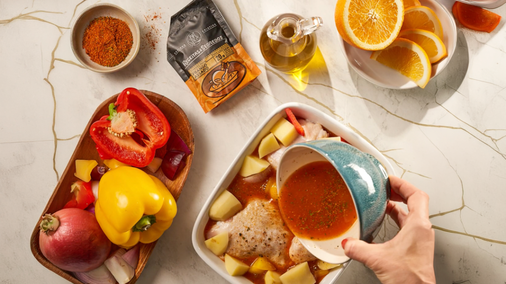 Mesa com ingredientes para o preparo do frango assado. Frutas, legumes e tempero.